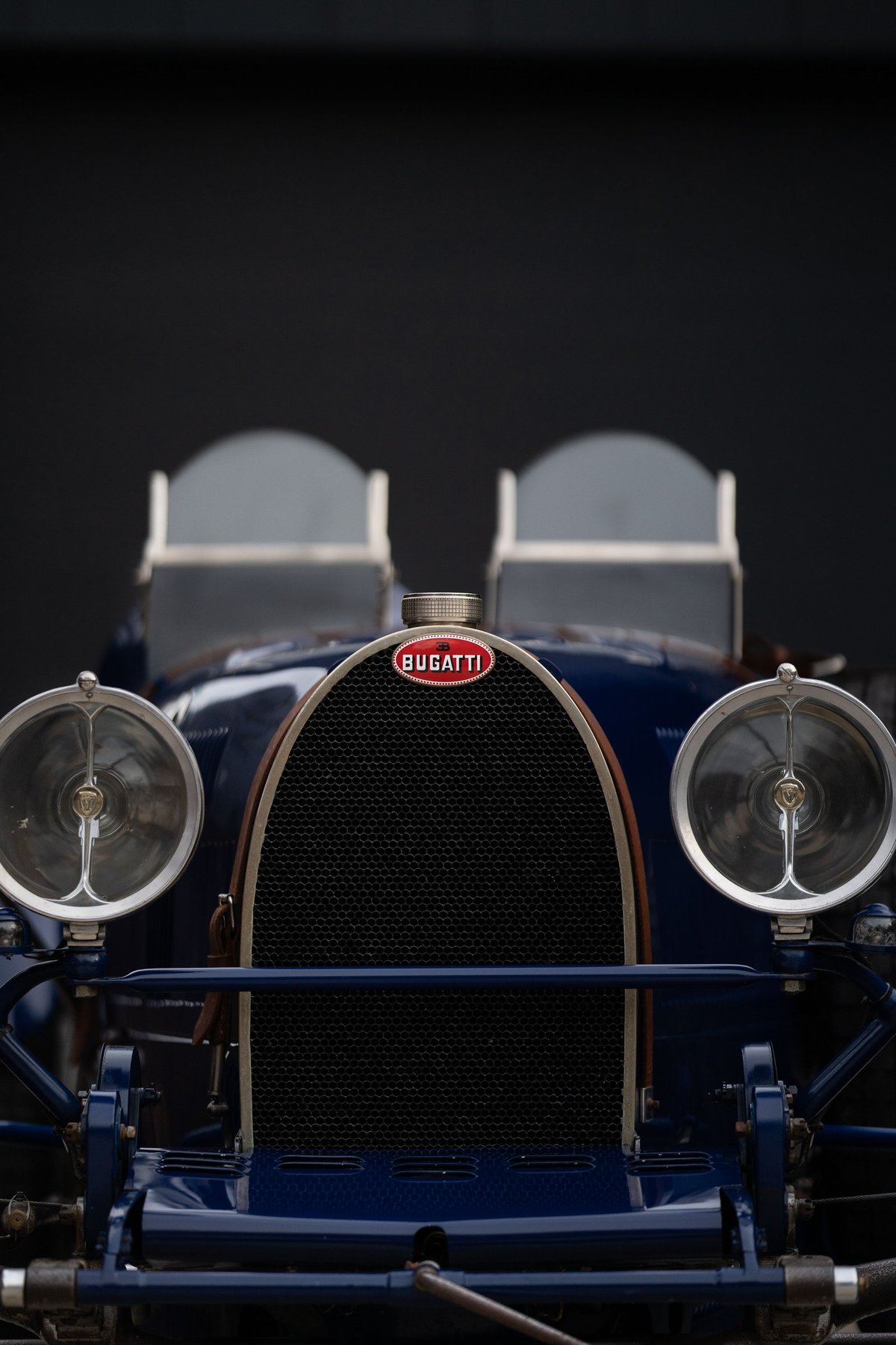 Front view of a vintage blue Bugatti Type 35, showing the iconic grille, headlights, and Bugatti emblem.