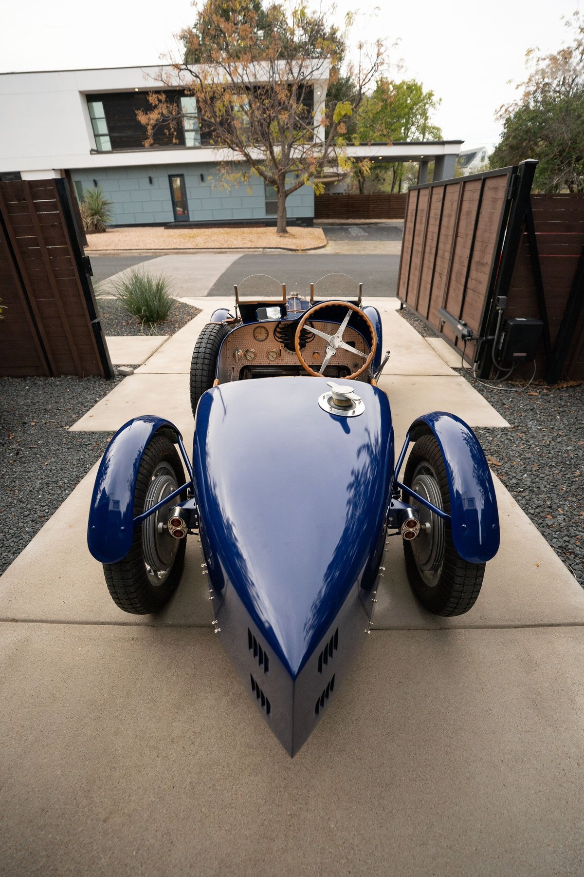 Front view of a blue 1927 Pur Sang Bugatti Type 35, showcasing its classic body and wire-spoke rims.