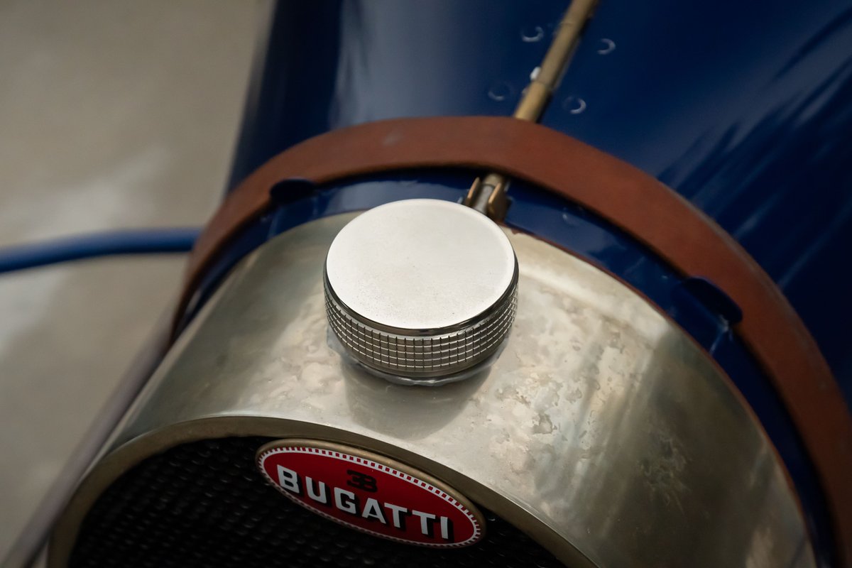 Close-up of a blue 1927 Bugatti Type 35 with a chrome fuel cap and vintage Bugatti badging.