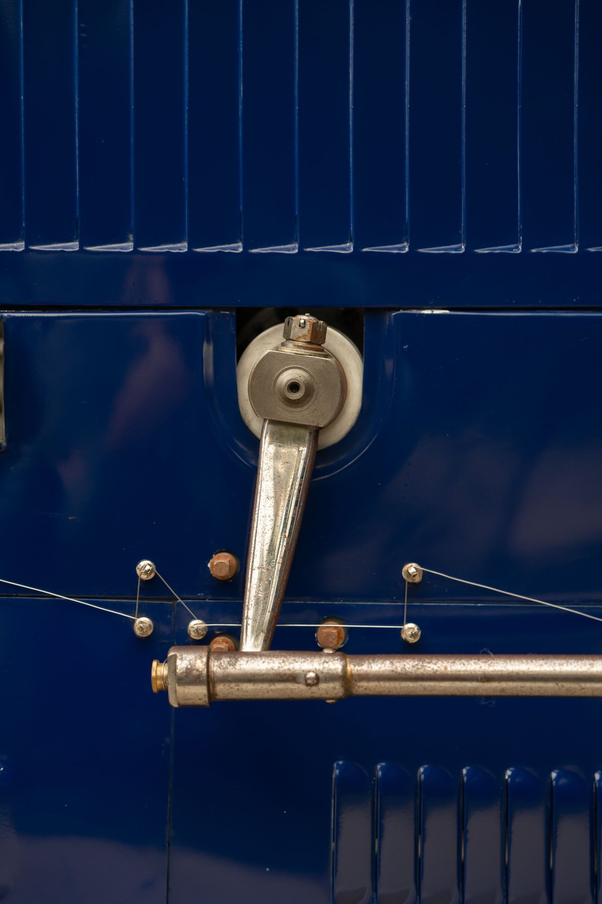 Close-up of a metal lever and cable system on a blue 1927 Bugatti Type 35 Pur Sang.
