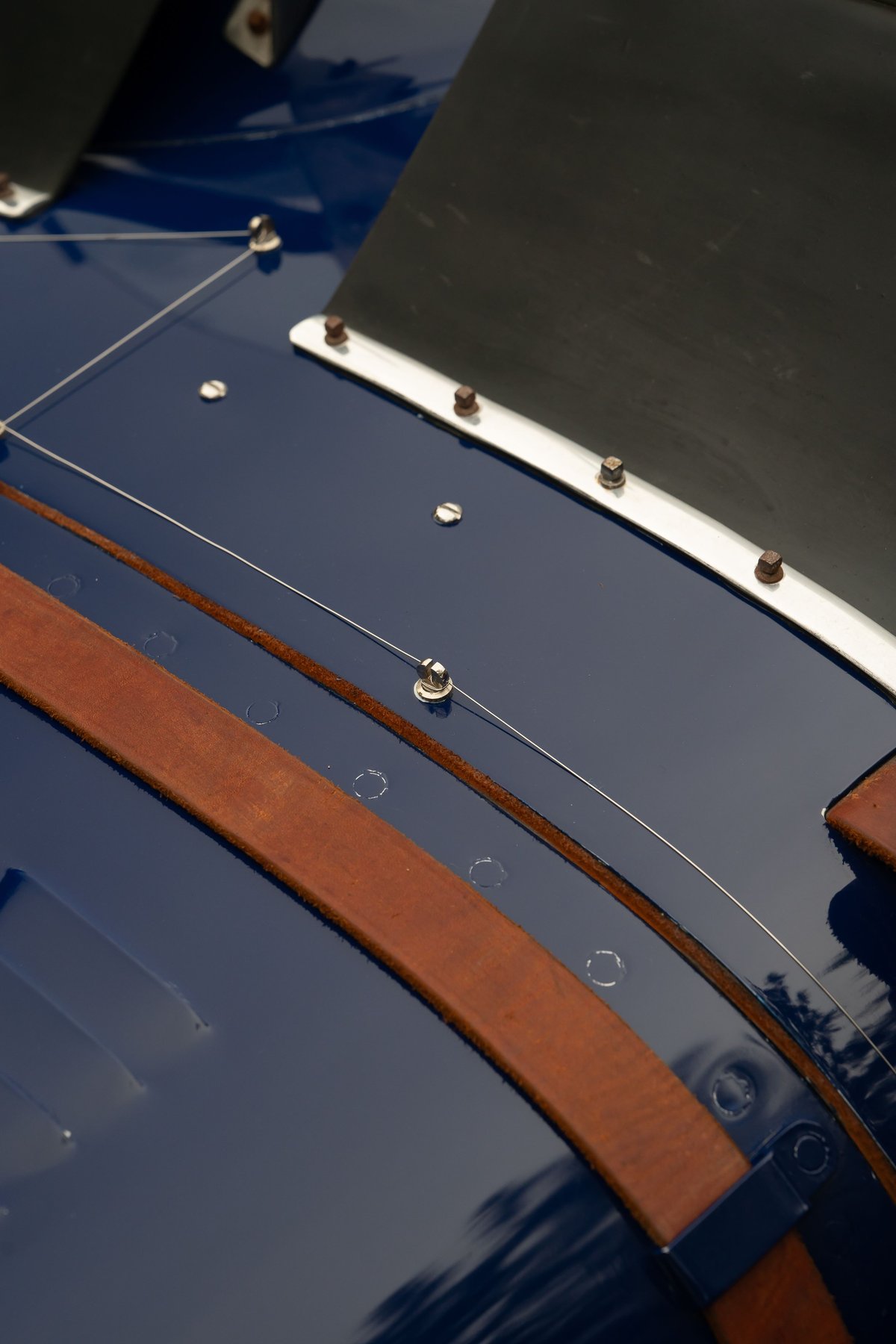 Close-up of a blue 1927 Bugatti Type 35 Pur Sang with leather hood straps and exposed rivets.