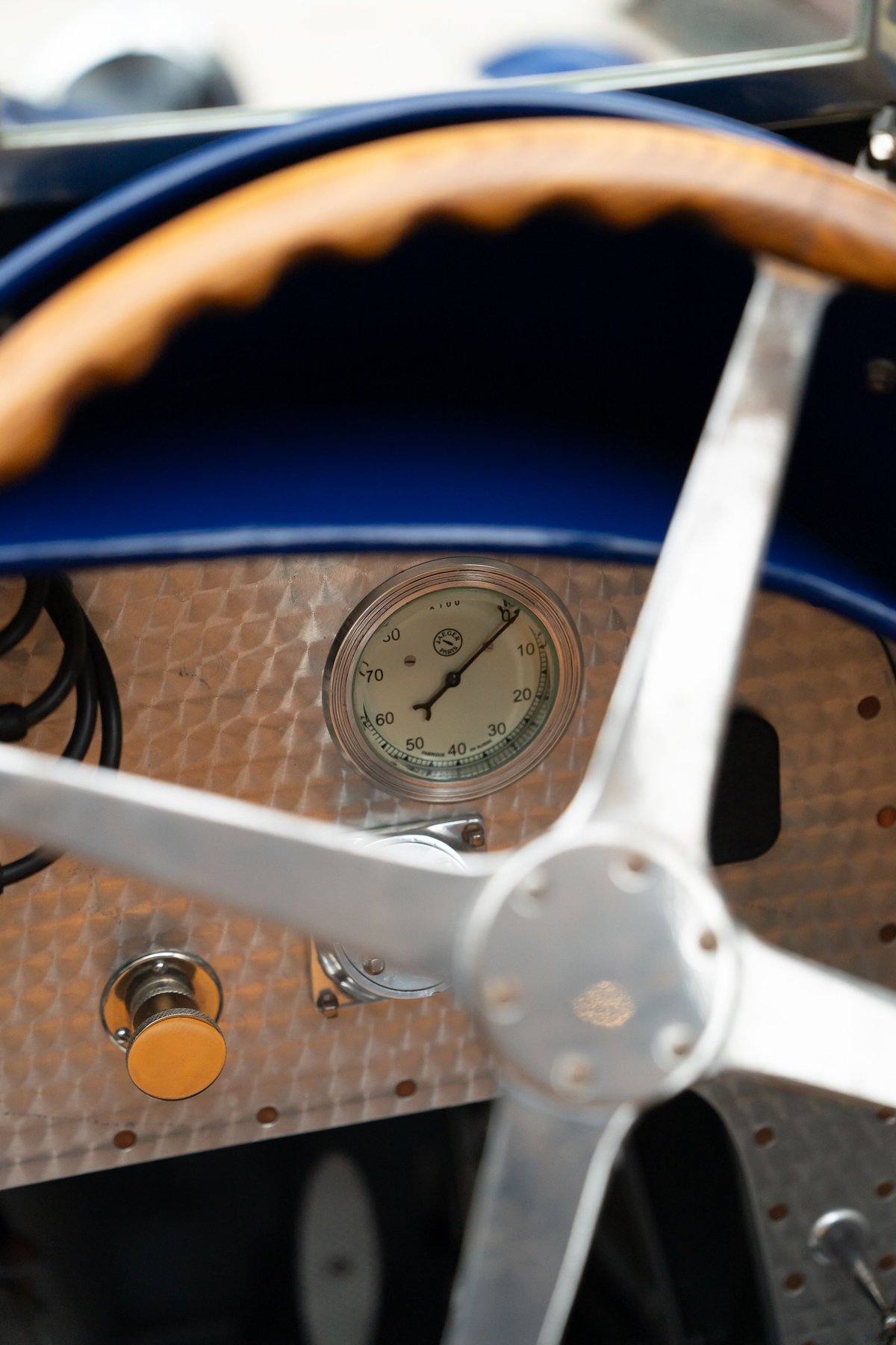 1927 Bugatti Type 35 dashboard with wood steering wheel and gauge.