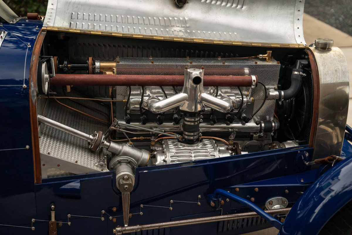Detailed view of the polished engine bay and vintage inline-eight engine in a blue 1927 Bugatti Type 35 Pur Sang.