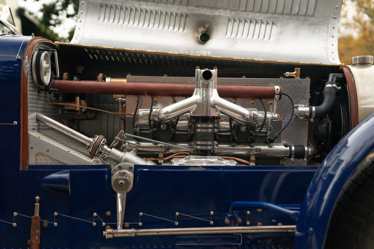 1927 Bugatti Type 35 engine bay, showcasing the intake manifold and exhaust headers on this blue classic race car.