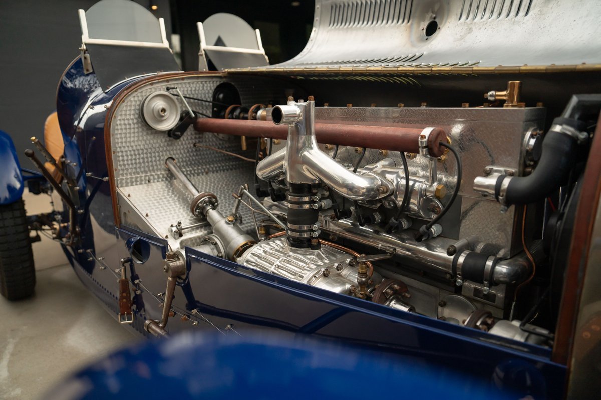 Detailed view of the engine bay of a blue 1927 Pur Sang Bugatti Type 35 race car, showcasing its mechanical components.
