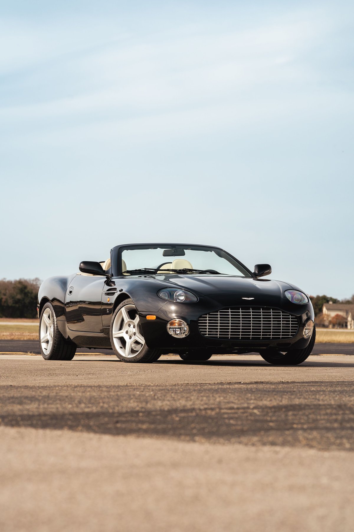 Black 2003 Aston Martin DB AR1 Zagato convertible with silver rims, tan interior, and chrome grille.