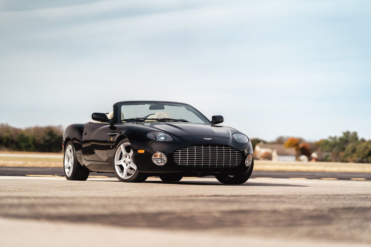 Black 2003 Aston Martin DB AR1 Zagato convertible with silver rims.