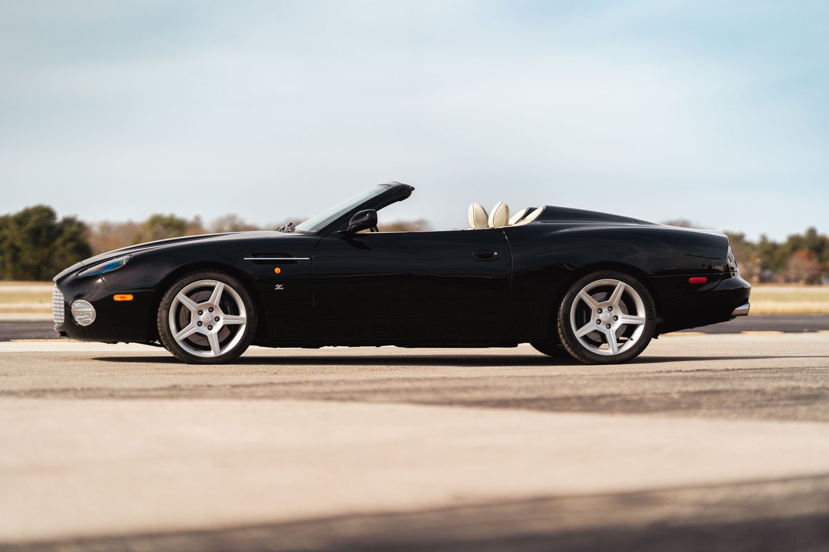Black 2003 Aston Martin DB AR1 Zagato convertible, showing its five-spoke rims and cream interior.