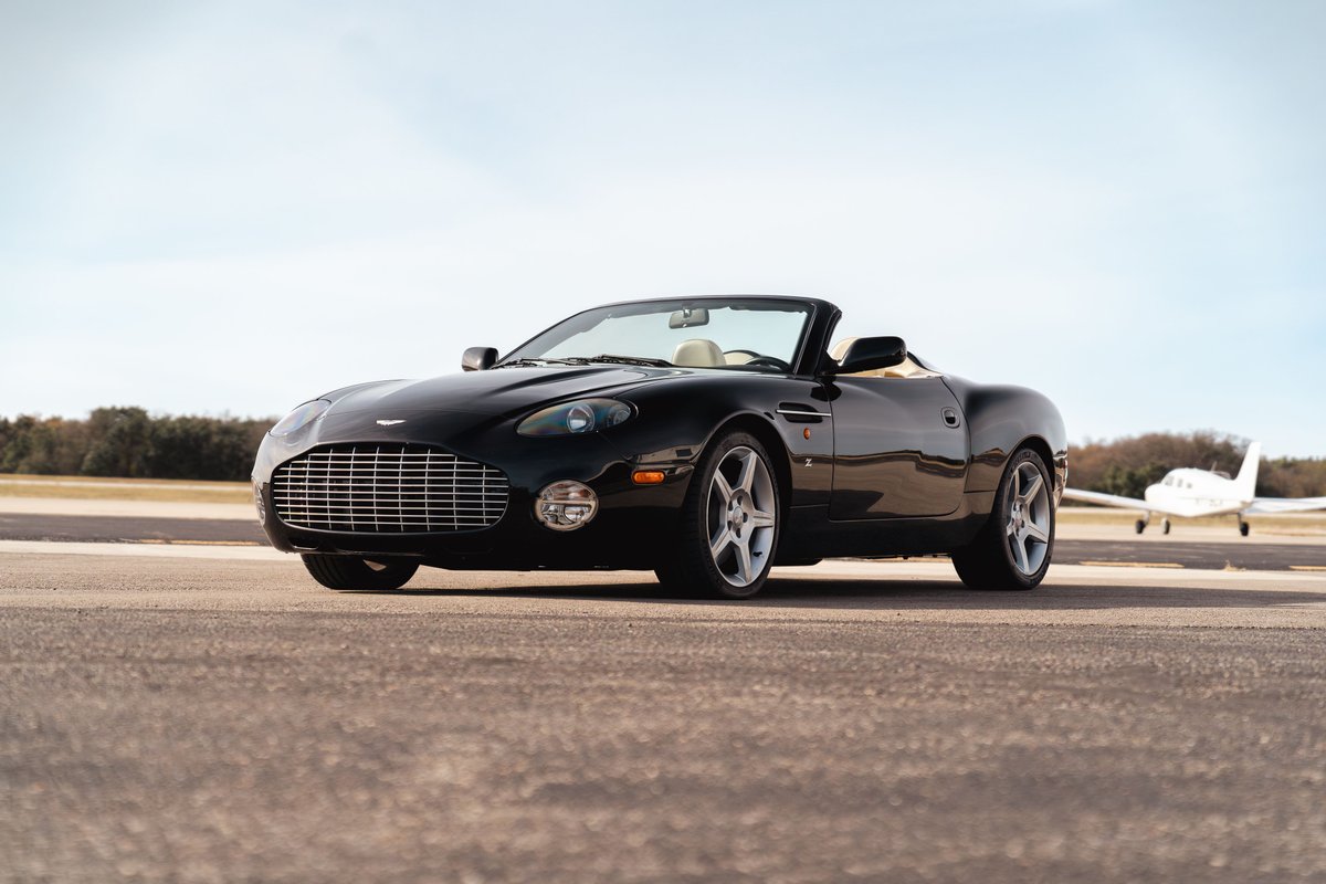 Black 2003 Aston Martin DB AR1 Zagato convertible with chrome rims and tan interior.