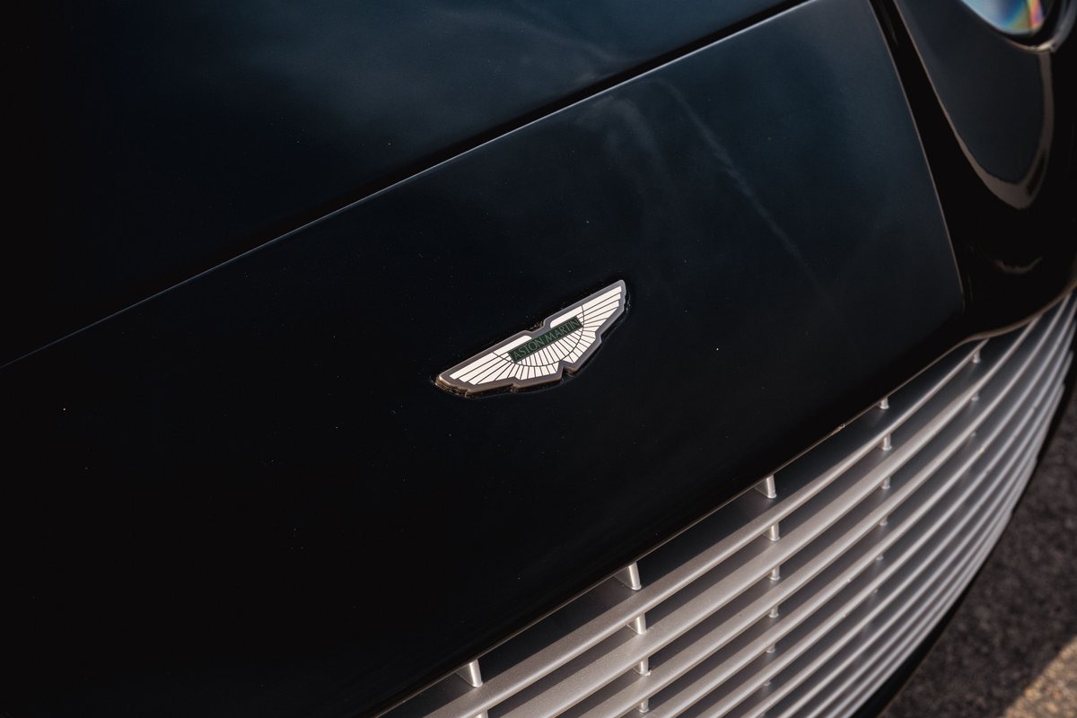Close-up of the Aston Martin wings badge and grille on a black 2003 Aston Martin DB AR1 Zagato.