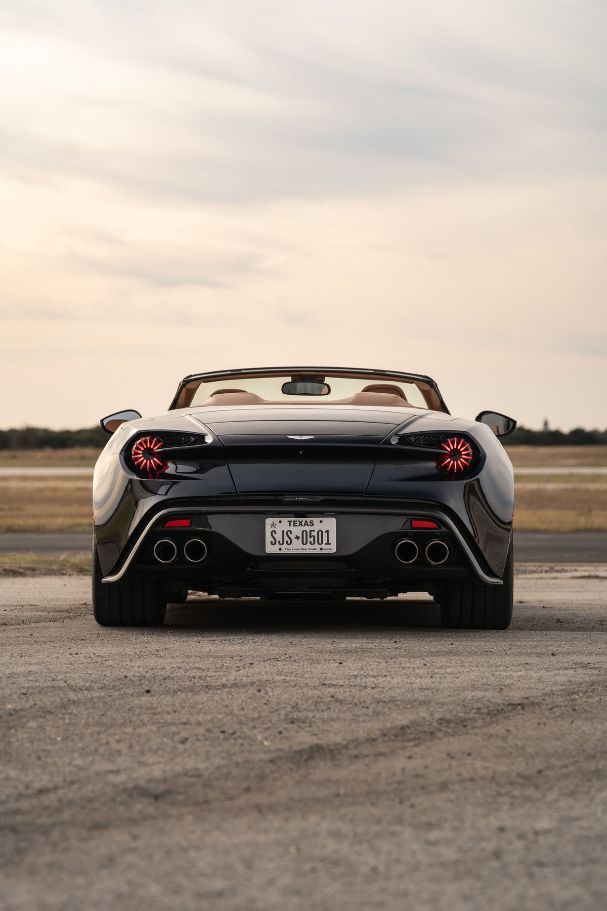 Rear view of a black 2018 Aston Martin Vanquish Zagato convertible with circular taillights.