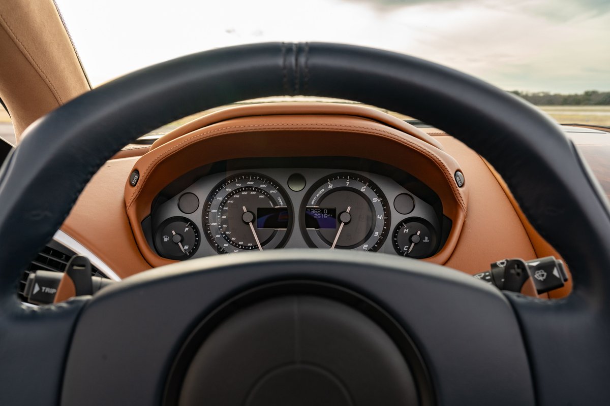 Interior view of a 2018 Aston Martin Vanquish Zagato with tan leather trim and a black steering wheel.