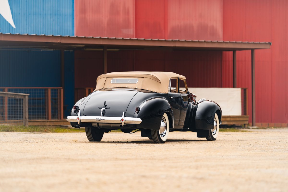1940 Packard Super Eight One Eighty convertible in black with a tan top, white-wall tires, and chrome trim.