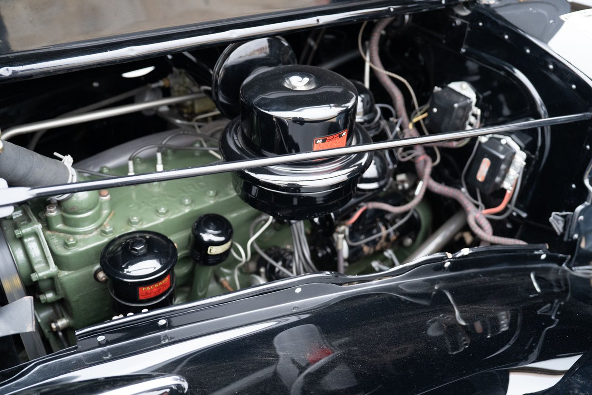 1940 Packard Super Eight One Eighty engine bay with dual carburetors and green engine block.