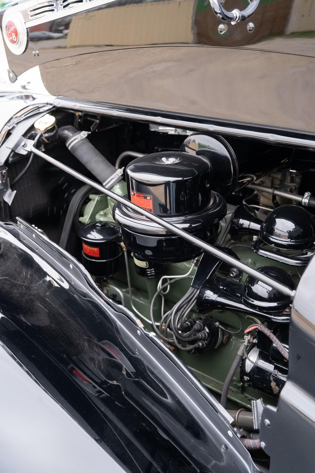 Close-up of a black 1940 Packard Super Eight's inline-eight engine, featuring a large air cleaner.