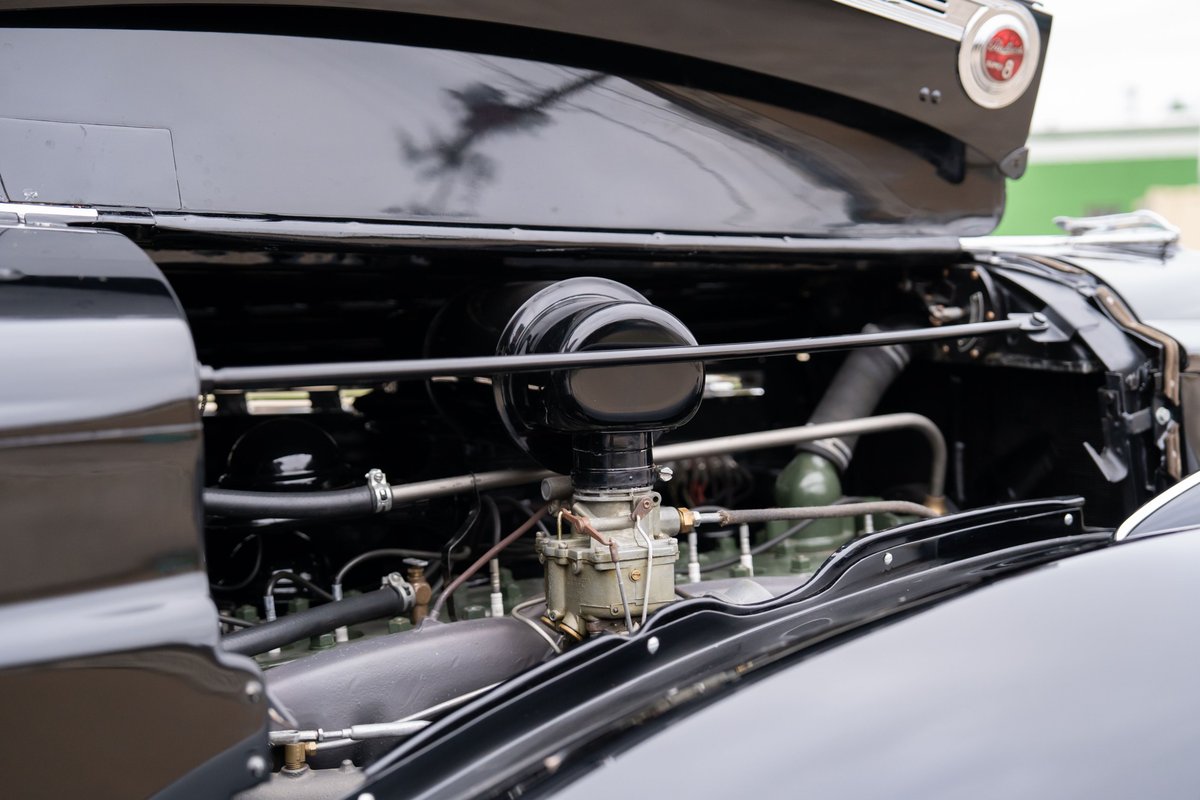 1940 Packard Super Eight One Eighty engine bay. Black paint, chrome trim, V8 engine.