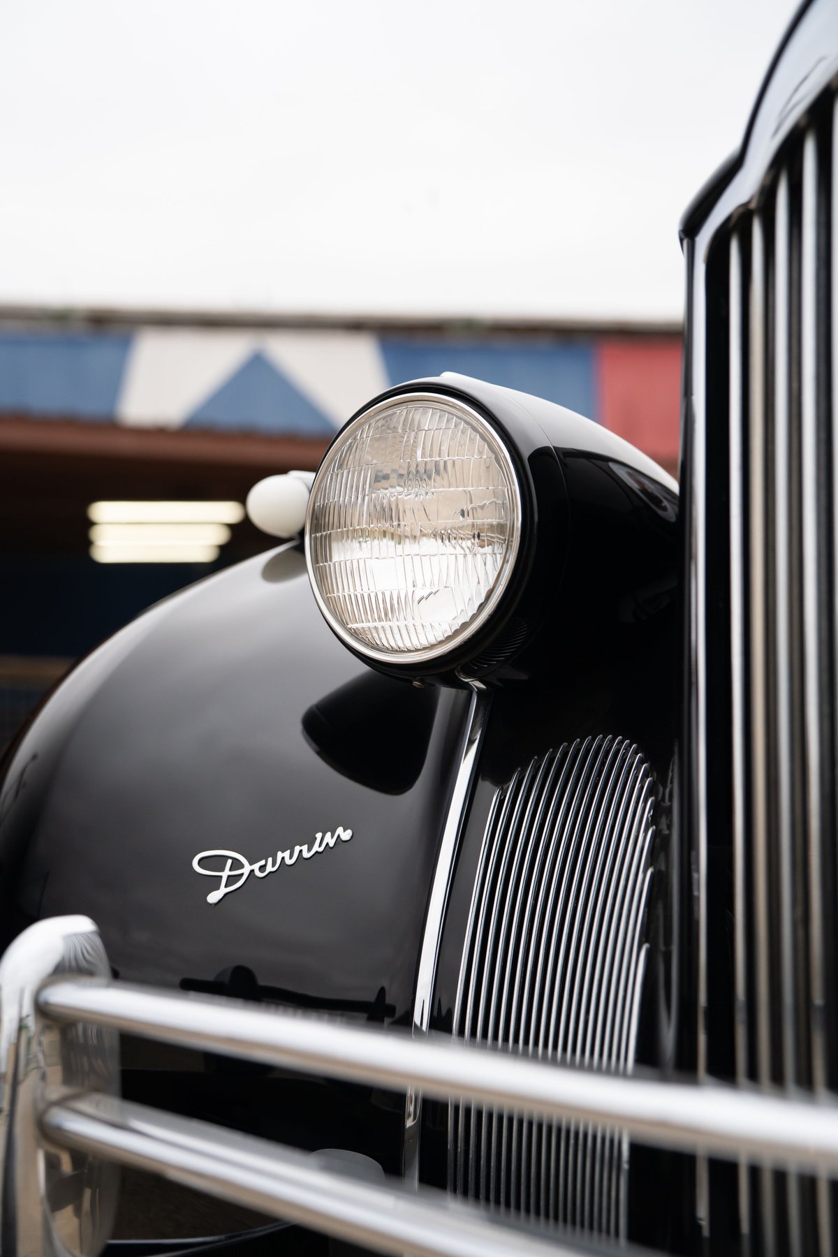 Close-up of a black 1940 Packard Super Eight One Eighty fender with a chrome grille and Darrin badging.