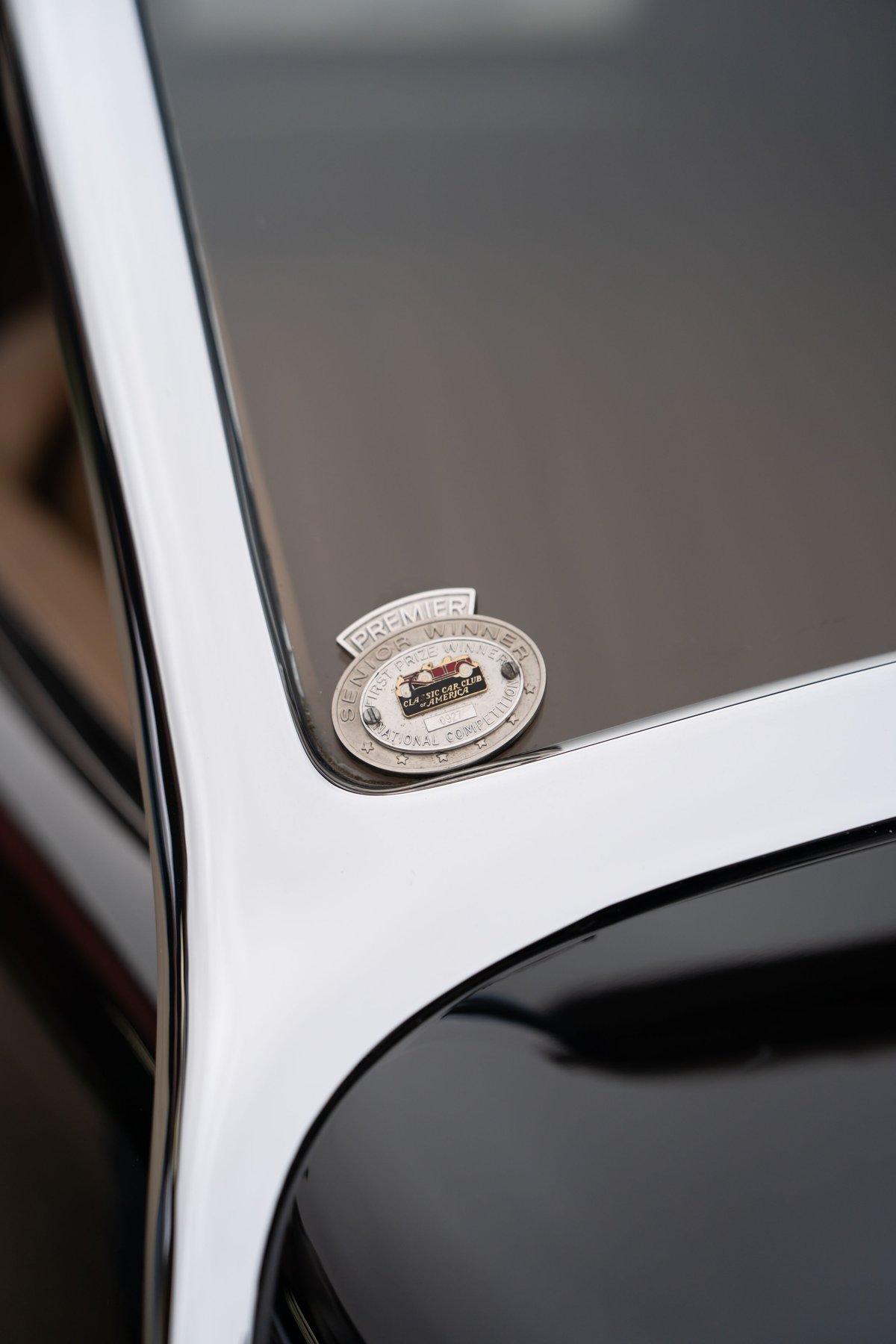 Close-up of a Packard Super Eight One Eighty emblem with chrome trim.