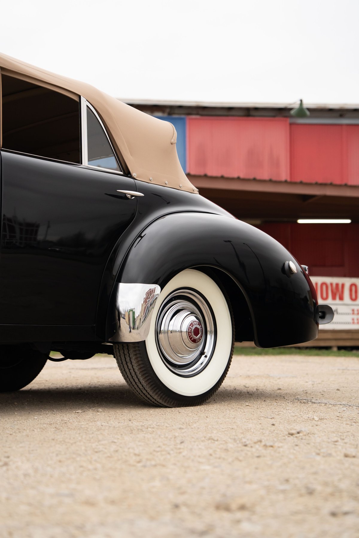 Black 1940 Packard Super Eight One-Eighty convertible top with whitewall tires and chrome trim.