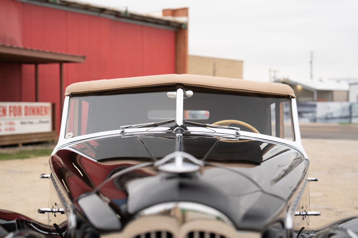 Close-up of a black 1940 Packard Super Eight One Eighty convertible with tan top and chrome trim.