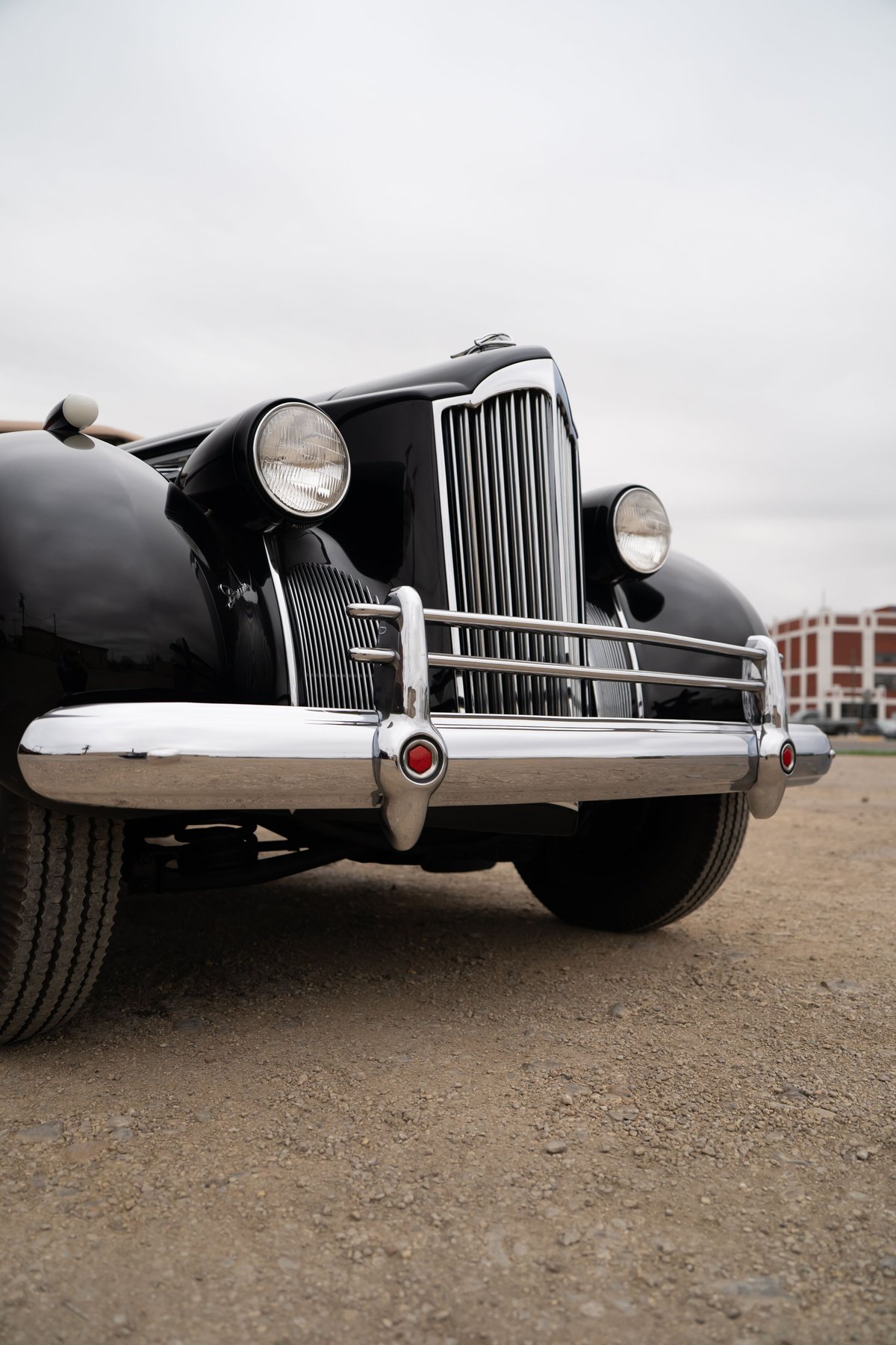 Front view of a black 1940 Packard Super Eight One Eighty, chrome grille, bumper, and headlights.