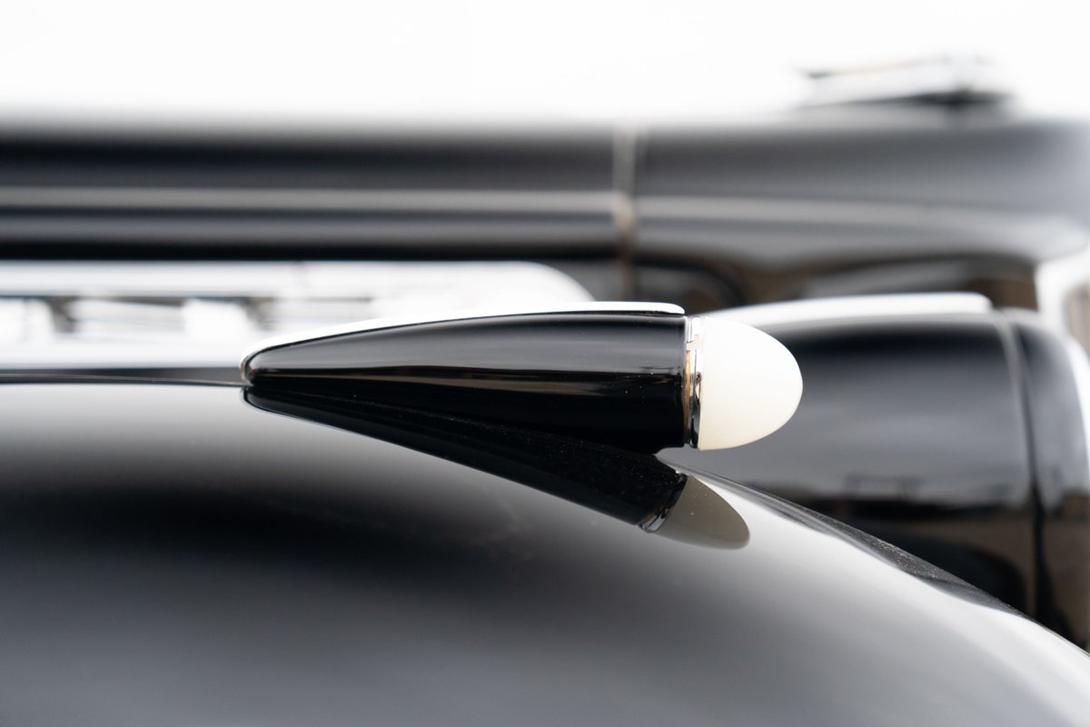 Close-up of a black 1940 Packard Super Eight One-Eighty's illuminated antenna.