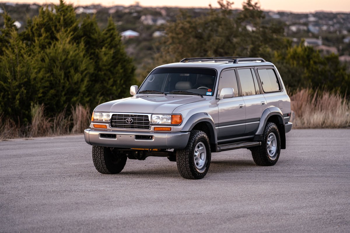 Silver 1997 Toyota Land Cruiser FZJ80 with grey lower body trim and alloy rims.