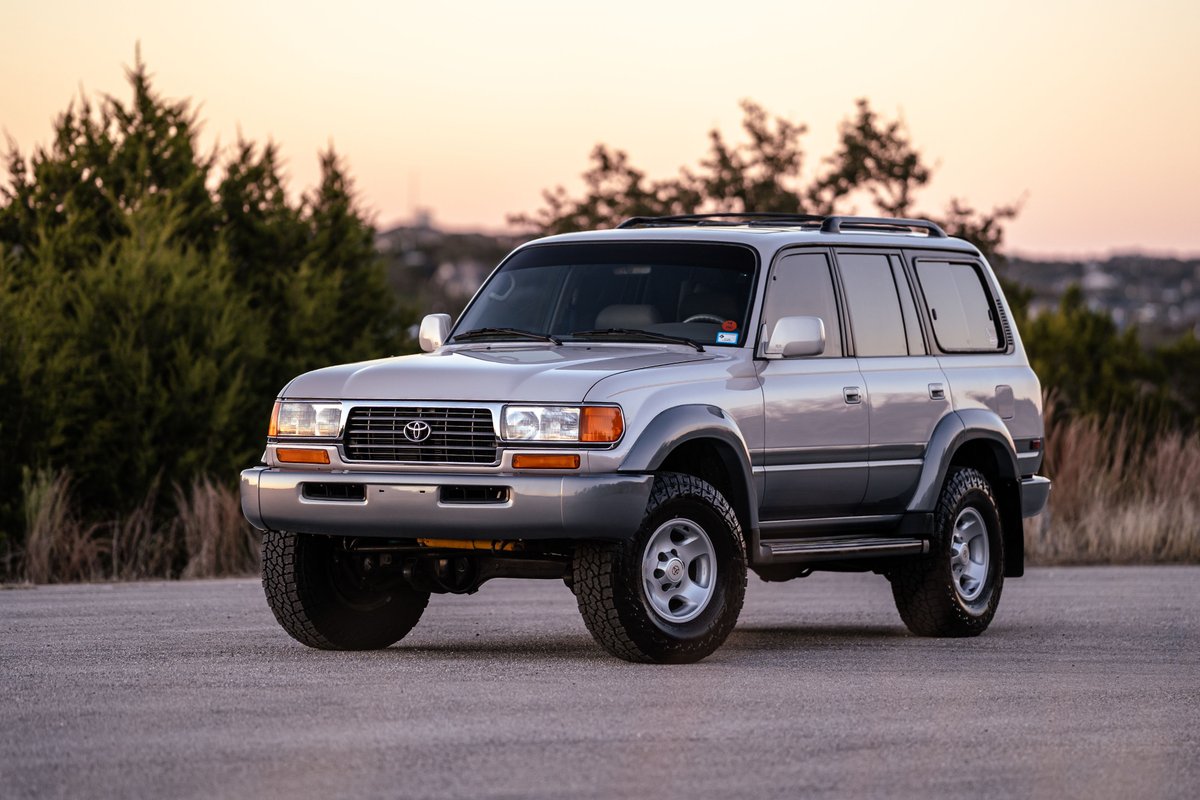 Silver 1997 Toyota Land Cruiser FZJ80 with factory rims and grey trim.