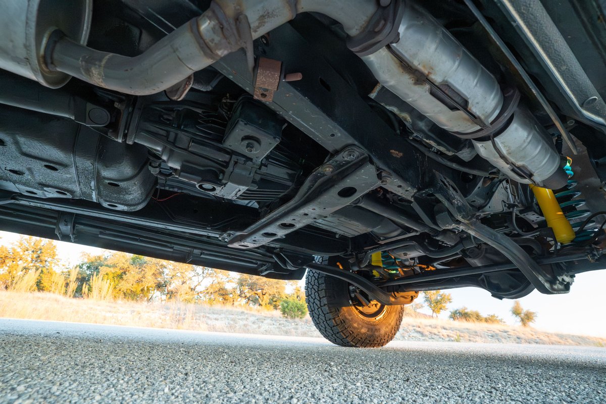 Underside of a 1997 Toyota Land Cruiser FJ80 showing drivetrain, exhaust and suspension.