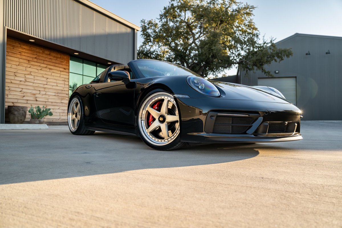 Black 2023 Porsche 911 Carrera 4 GTS Targa with custom rims and red brake calipers.