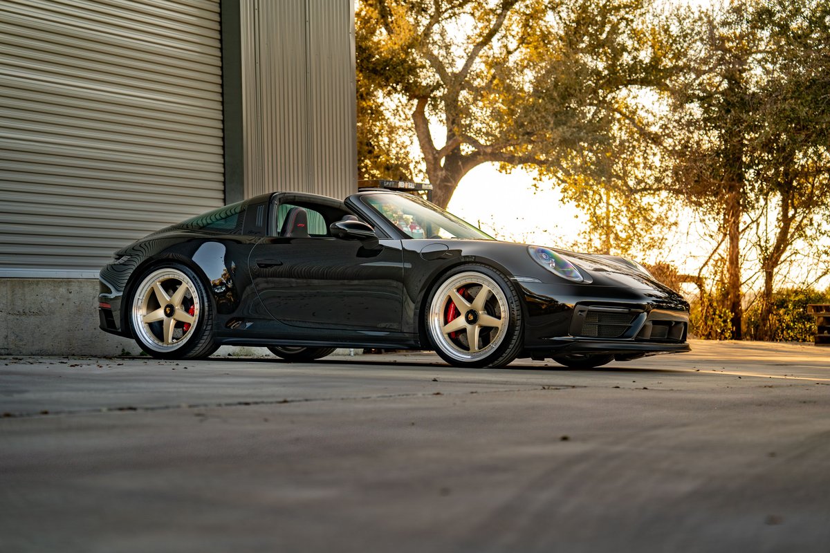 Black 2023 Porsche 911 Carrera 4 GTS Targa with gold multi-spoke rims.