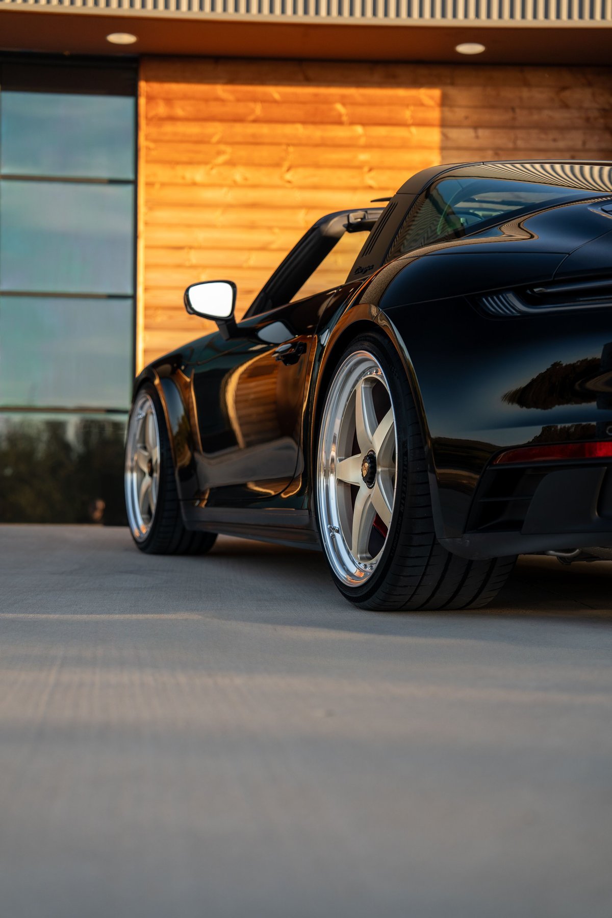 Black 2023 Porsche 911 Carrera 4 GTS Targa with polished multi-spoke rims.