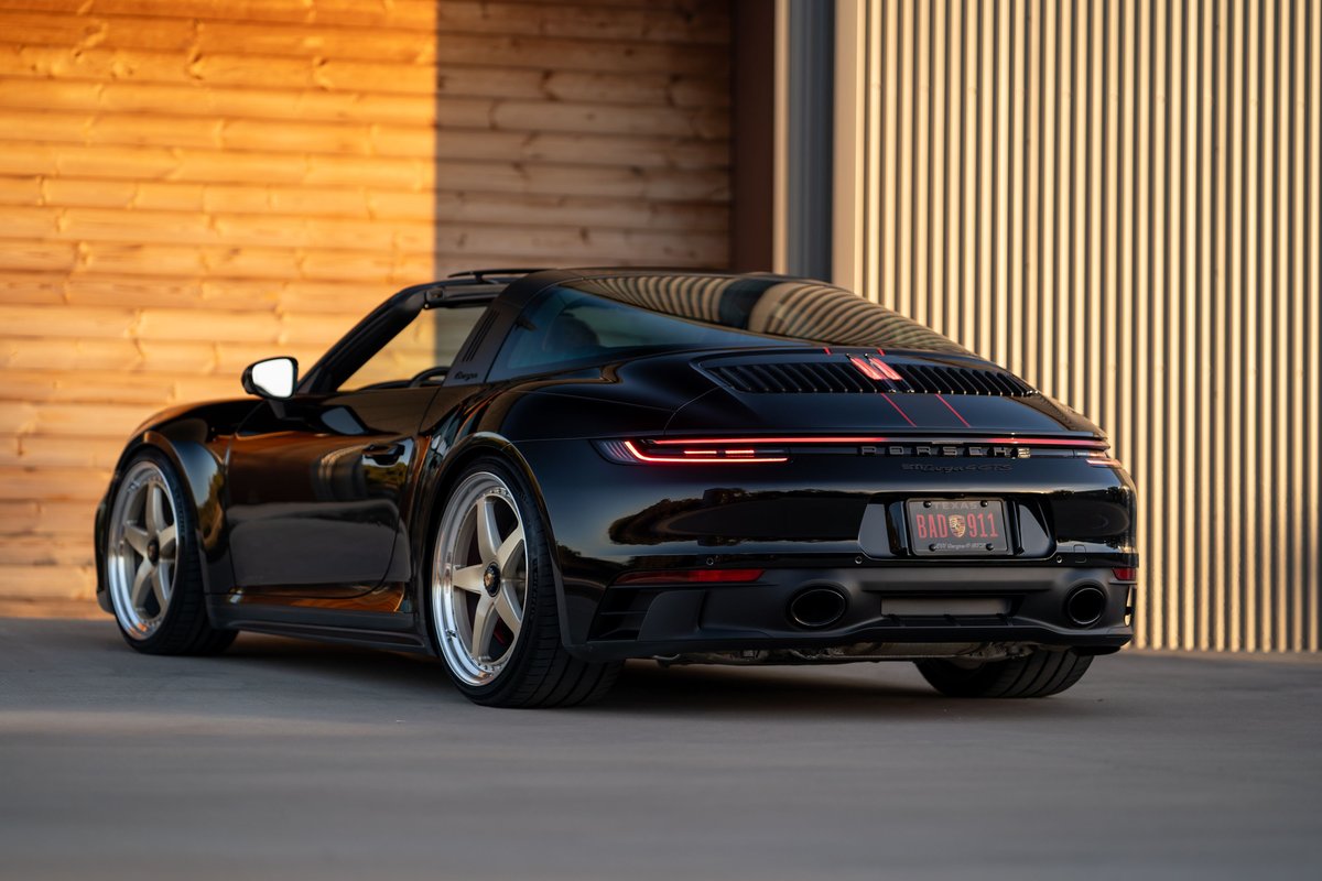 2023 Porsche 911 Carrera 4 GTS Targa in black, silver rims, red stripe livery.