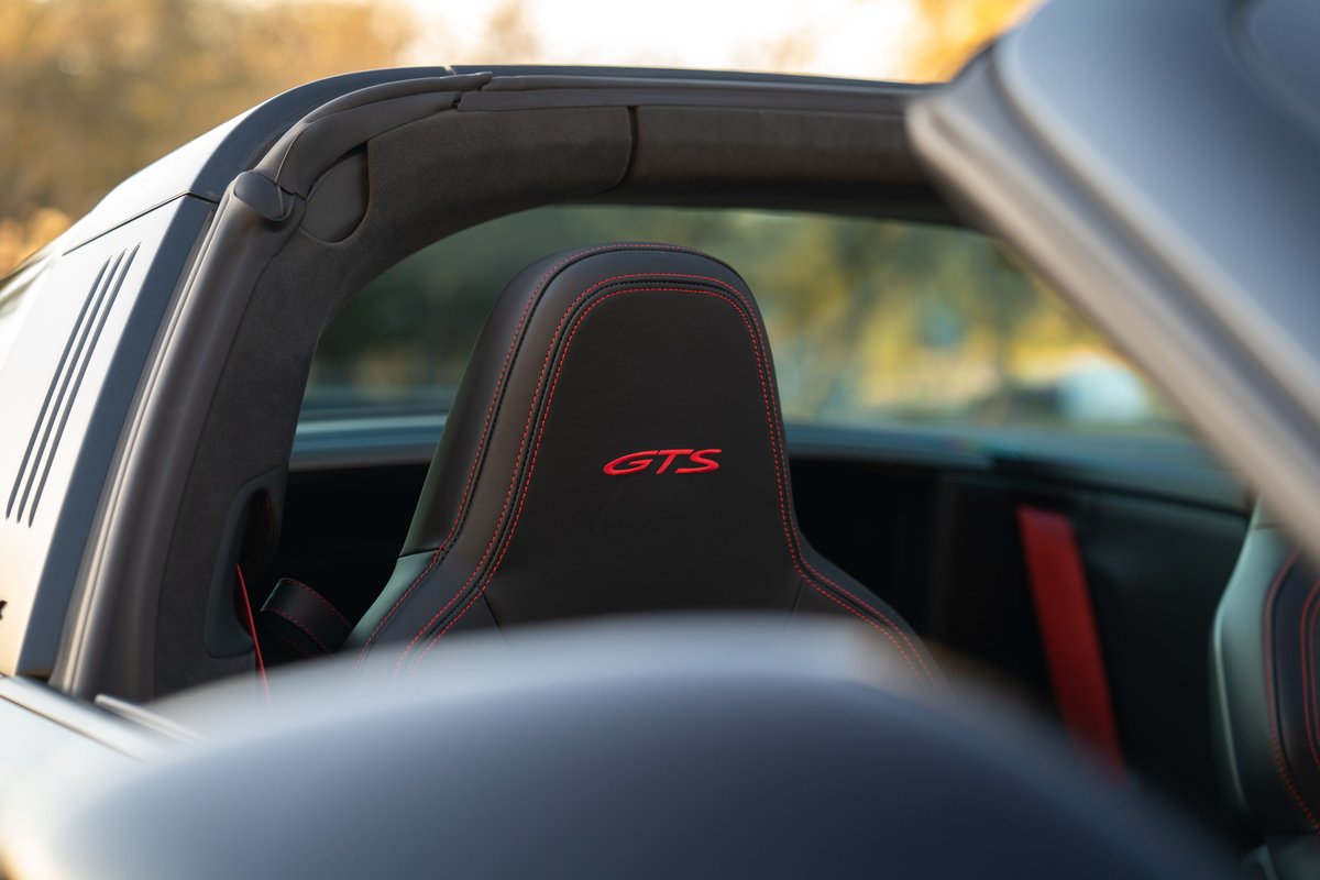 Interior view of a black 2023 Porsche 911 Carrera 4 GTS Targa with red GTS embroidery.