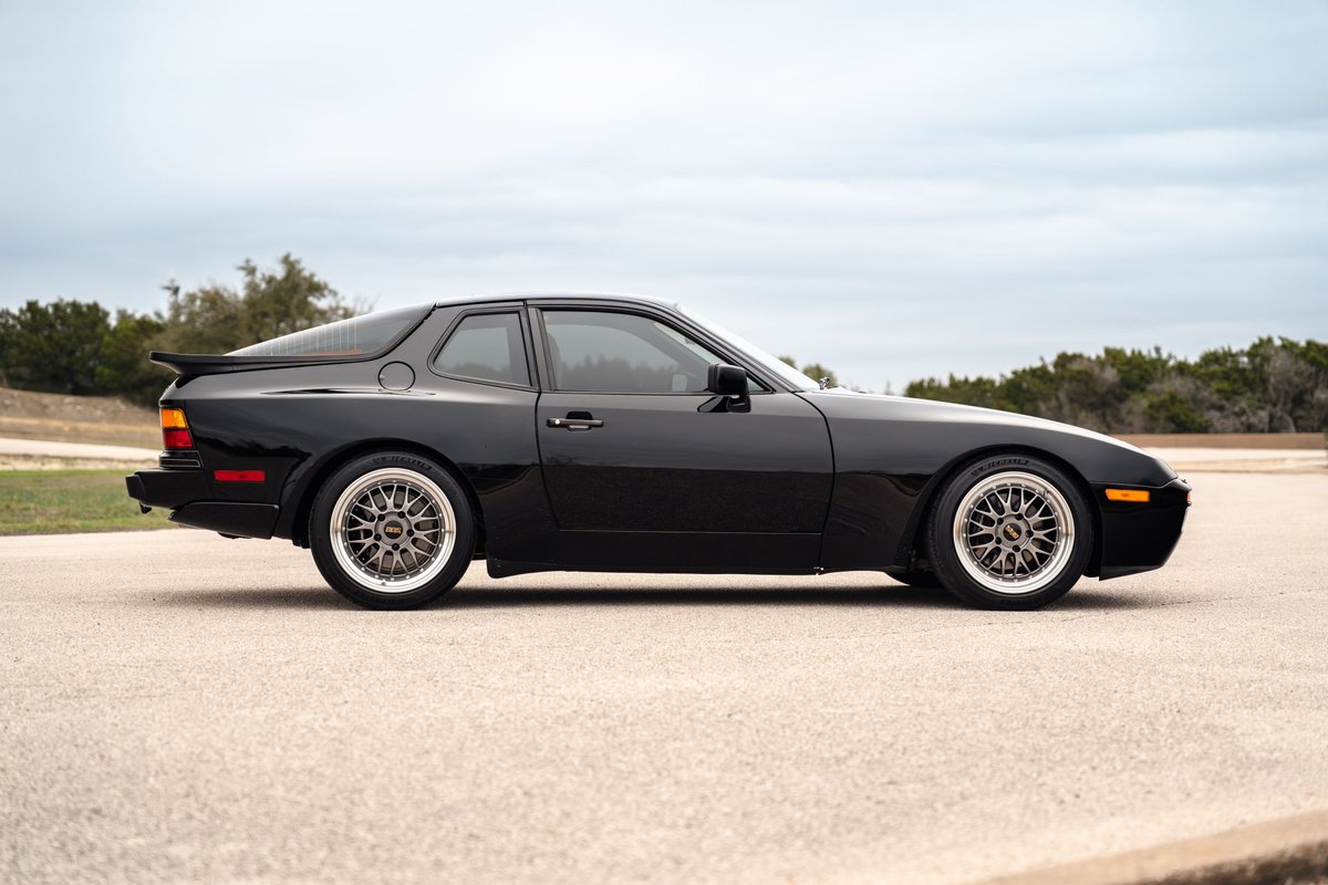 Black 1986 Porsche 944 Turbo with silver mesh rims and a rear spoiler.