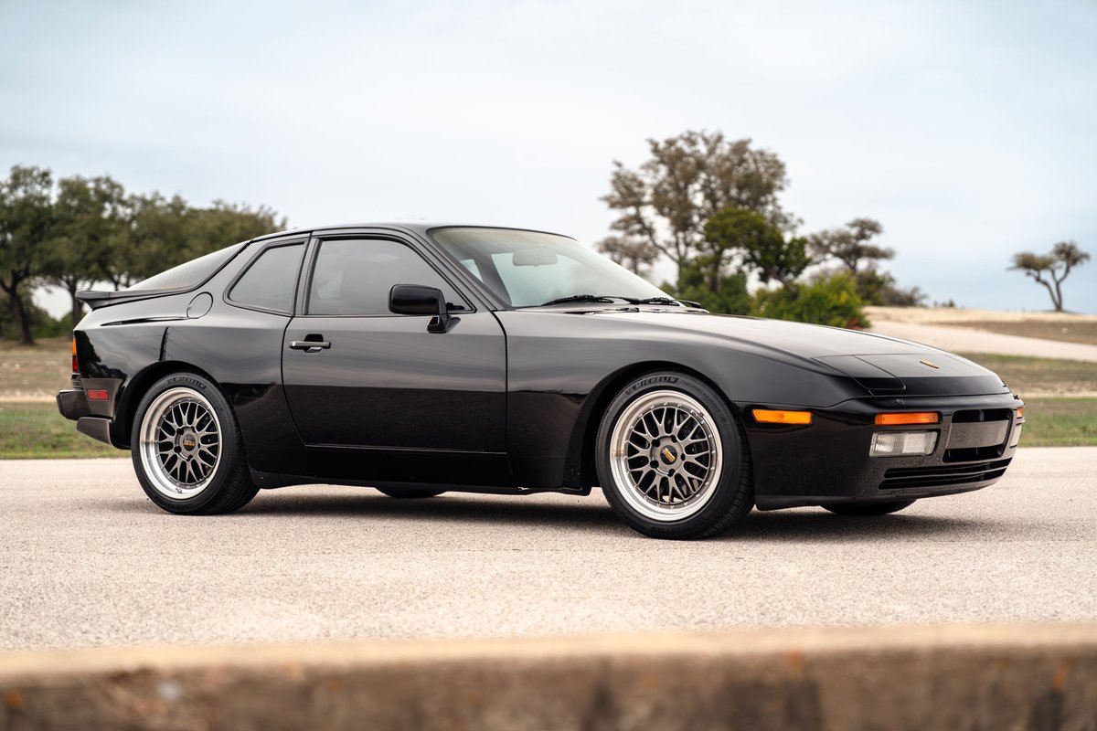 Black 1986 Porsche 944 Turbo with BBS rims and a rear spoiler.