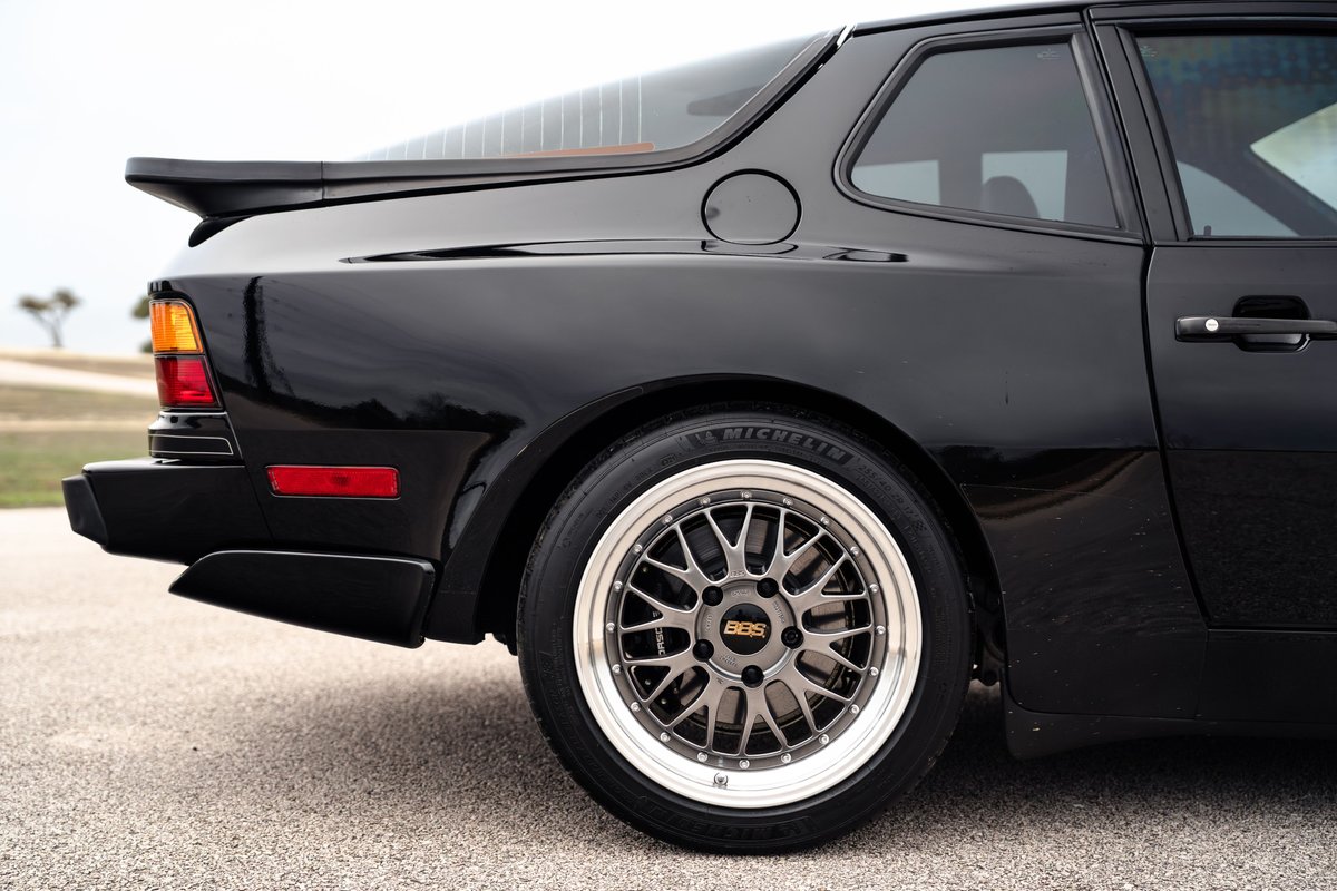 Black 1986 Porsche 944 Turbo rear quarter panel with BBS rims and a rear spoiler.