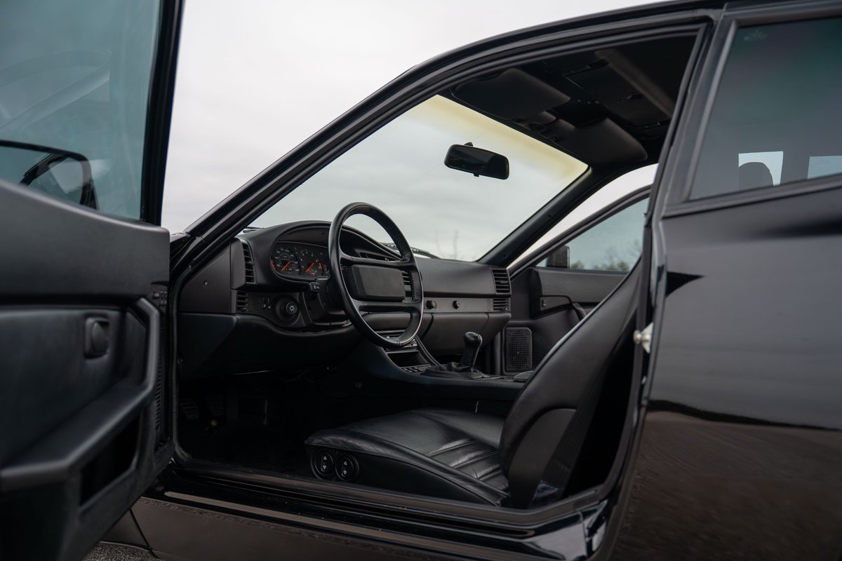 Interior view of a black 1986 Porsche 944 Turbo, showing dashboard and driver's seat.