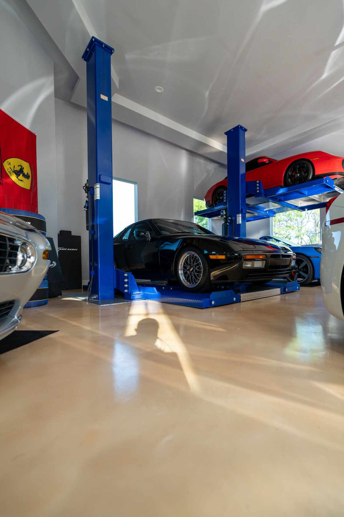 Black 1986 Porsche 944 Turbo on a car lift with mesh rims.