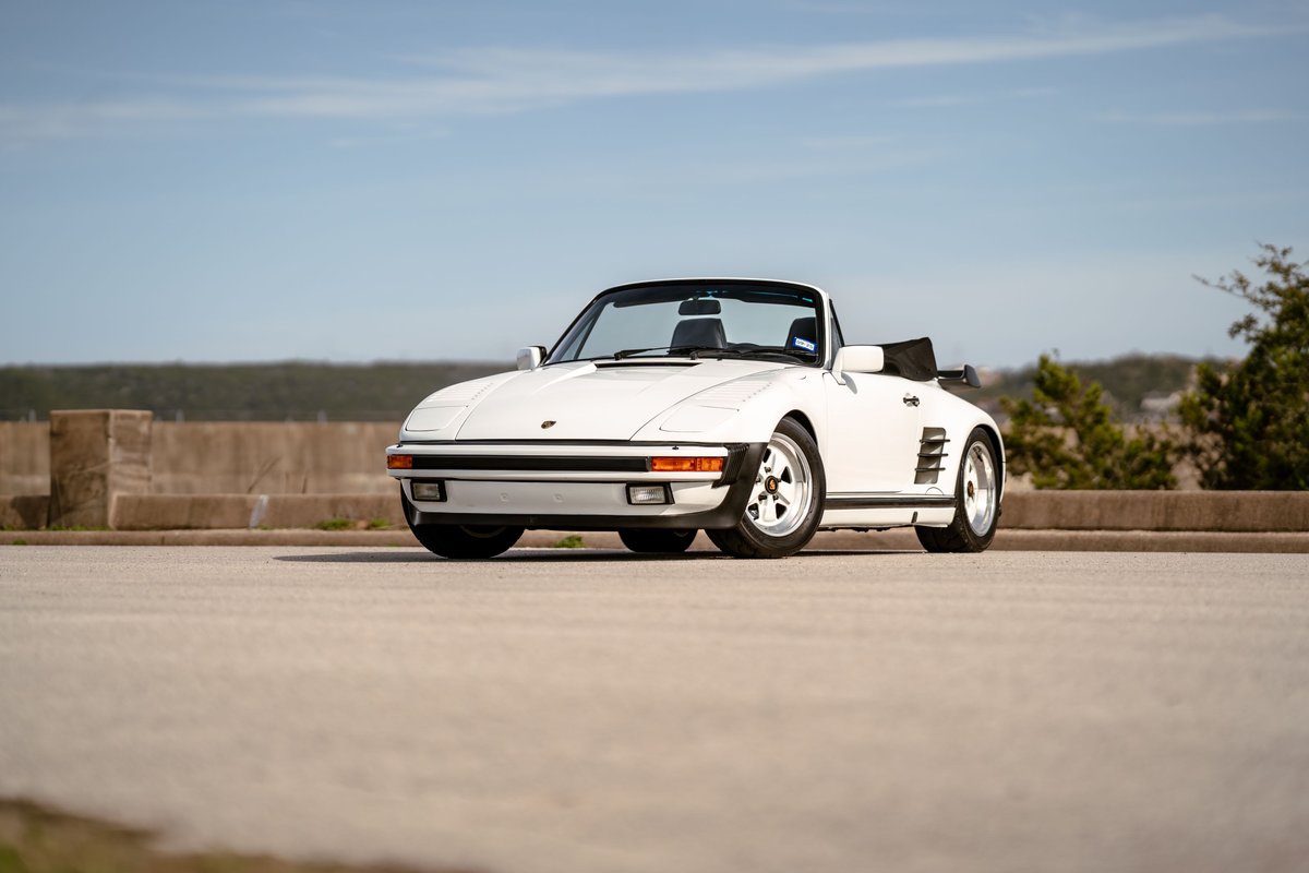 White 1988 Porsche 930 Turbo Slantnose convertible with Fuchs wheels and black soft top.