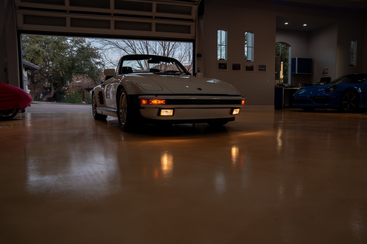 1988 white Porsche 930 Slantnose Turbo convertible with black trim and classic alloy rims.