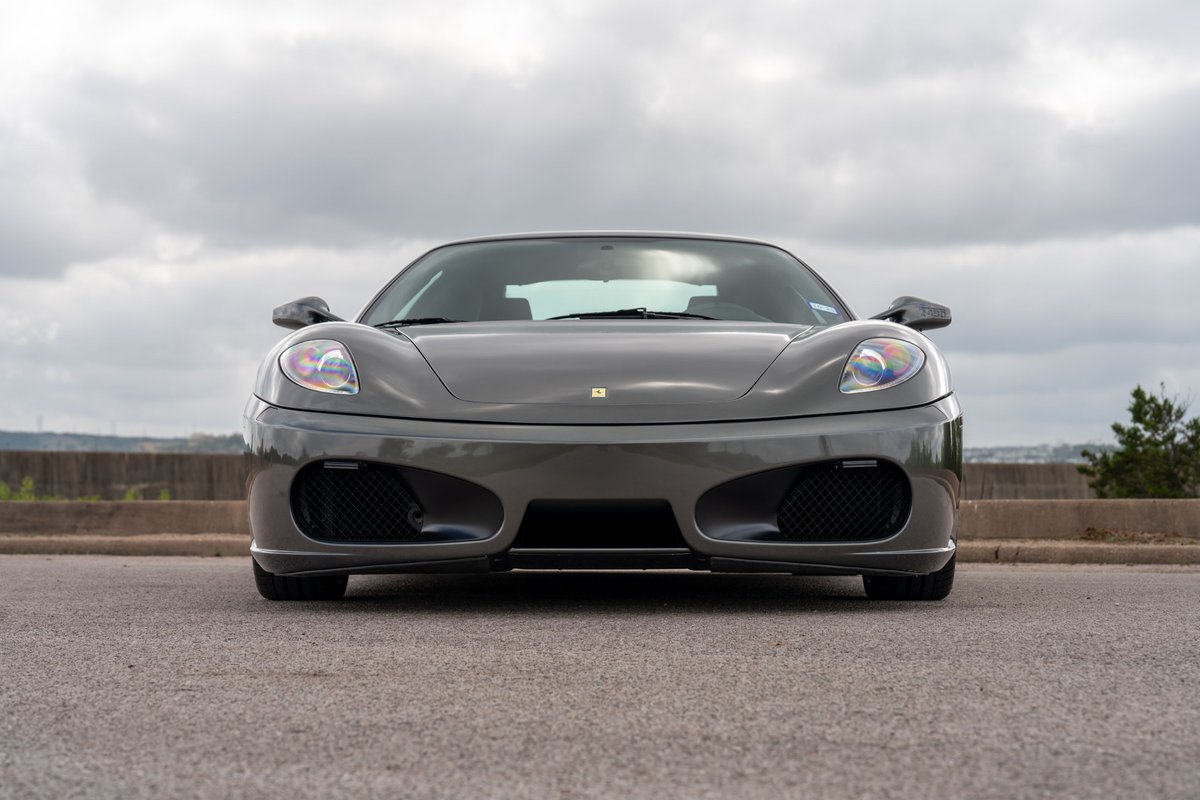 Front view of a Grigio Silverstone 2007 Ferrari F430 6-speed with black grilles and chrome trim.