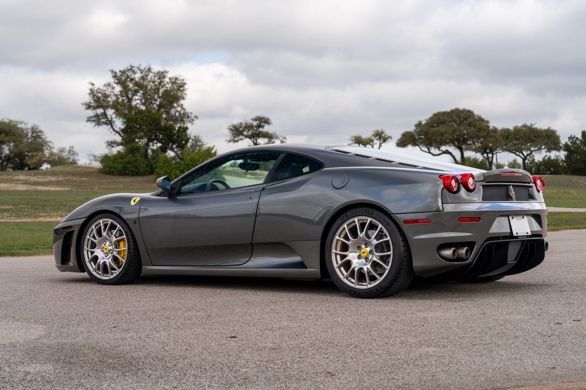 2007 Ferrari F430 in Grigio Silverstone, showing its silver multi-spoke rims and yellow brake calipers.