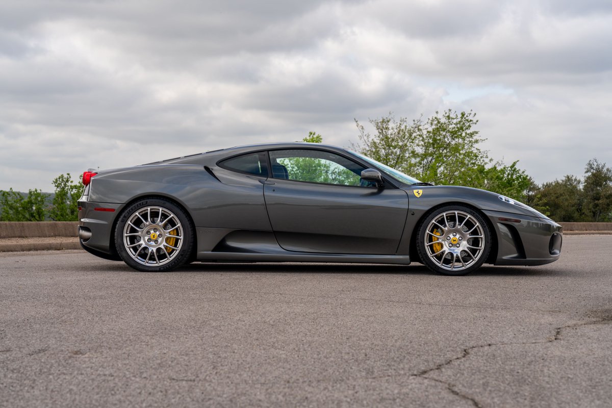 2007 Ferrari F430 coupe in Grigio Silverstone with yellow brake calipers and multi-spoke alloy rims.