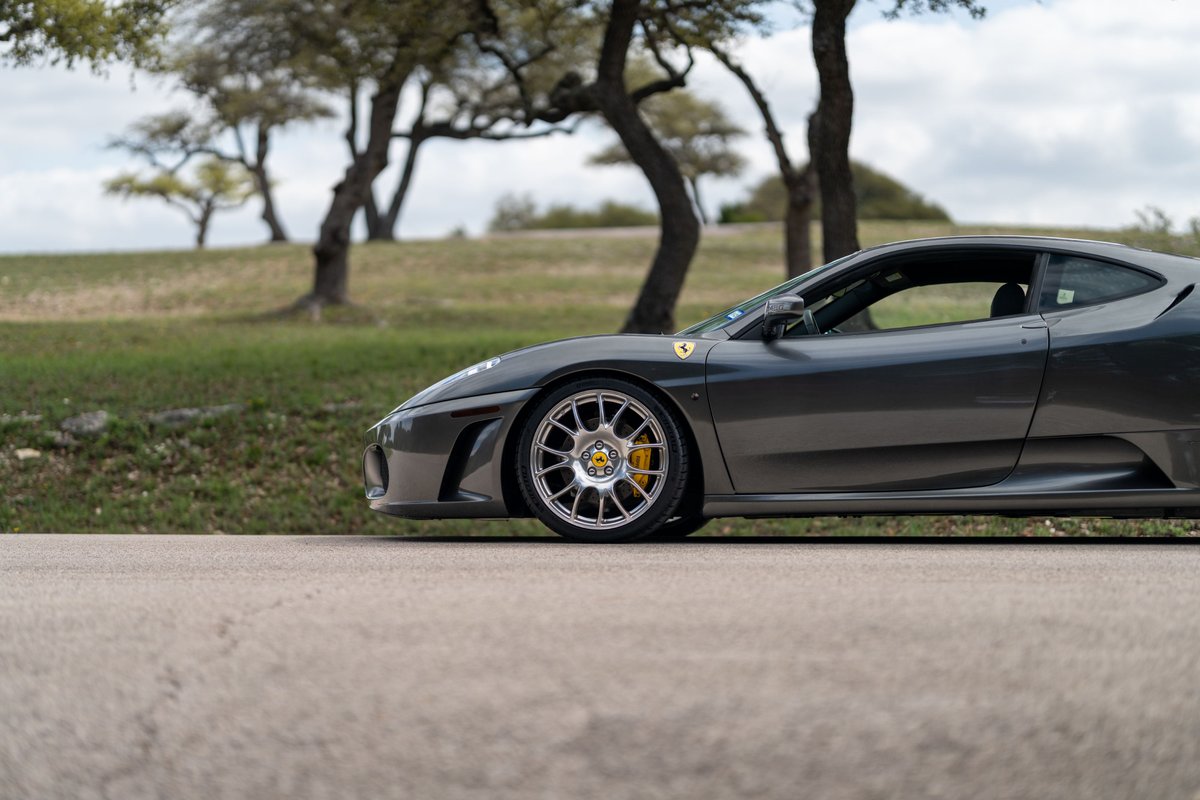 Side profile of a Grigio Silverstone 2007 Ferrari F430 6-speed with aftermarket mesh rims and yellow brake calipers.