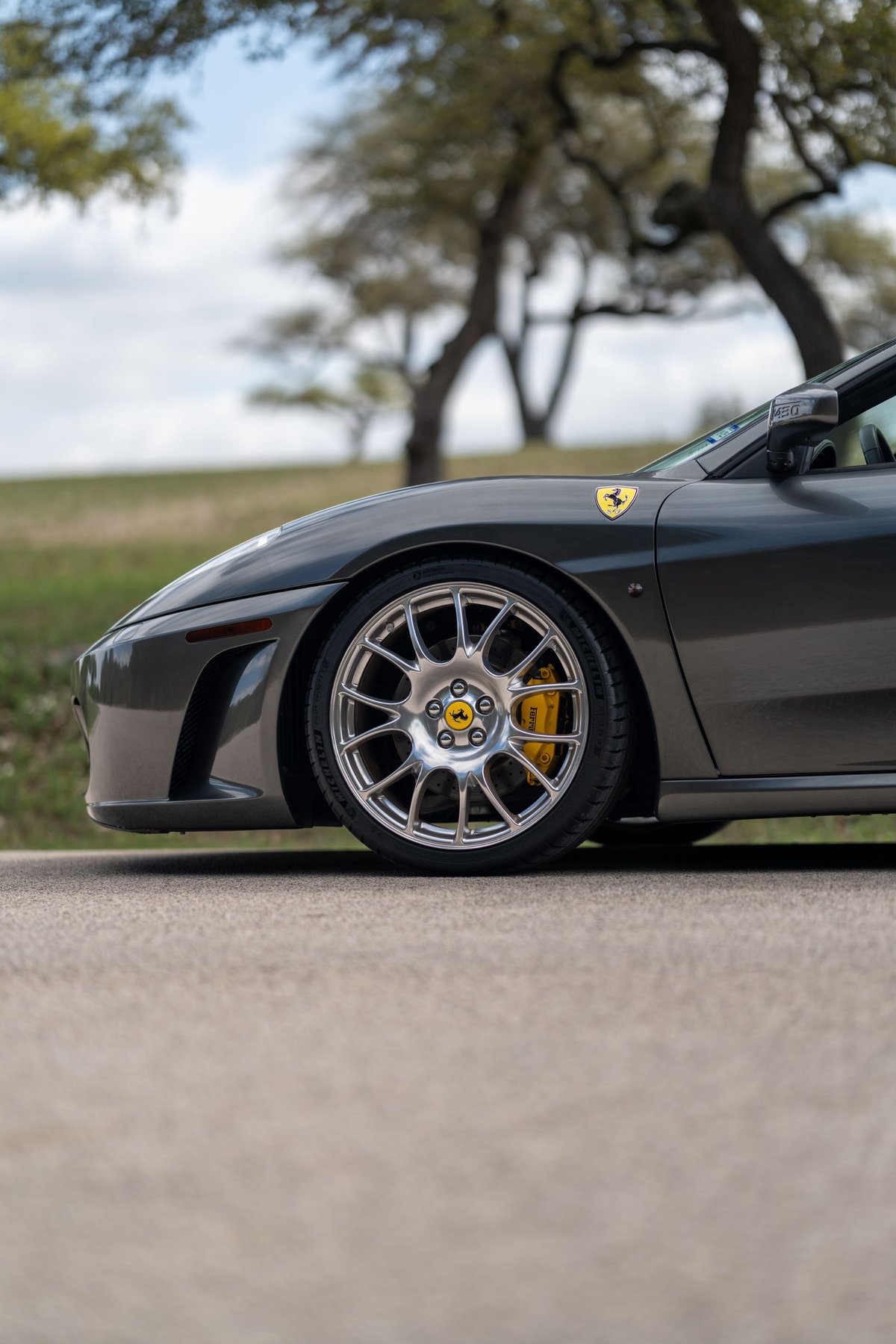 Grigio Silverstone 2007 Ferrari F430 with silver multi-spoke rims and yellow brake calipers.
