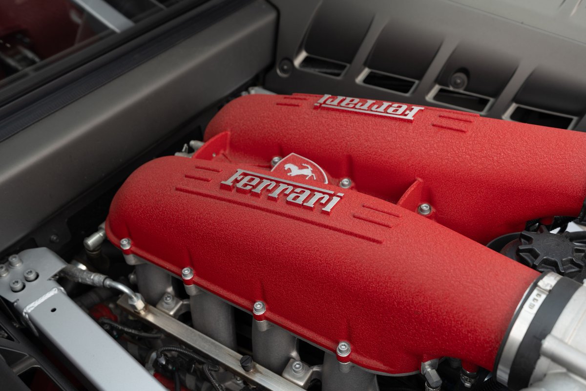 Close up of red Ferrari F430 engine covers with silver Ferrari script.