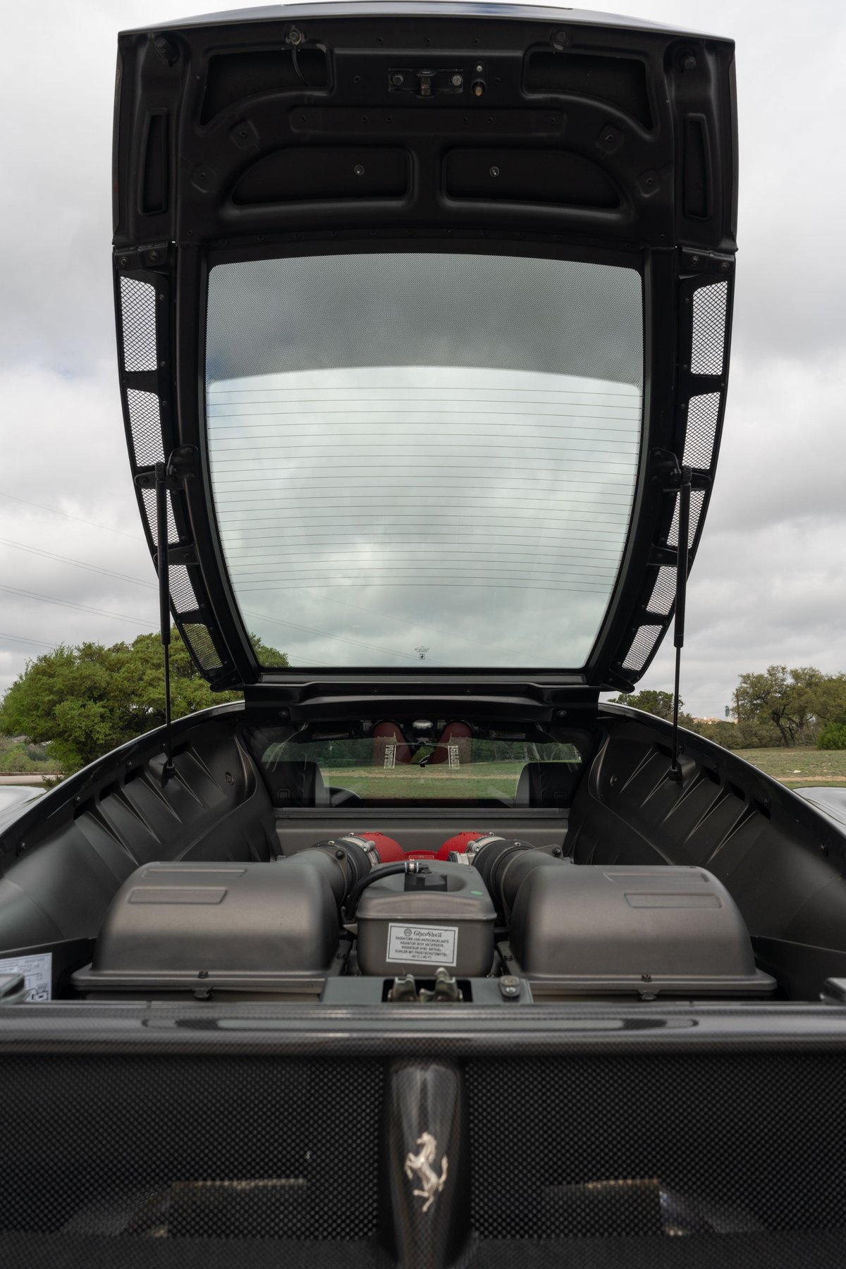 Ferrari F430 6-speed engine bay with twin intake plenums and red air intake trumpets. Grigio Silverstone.