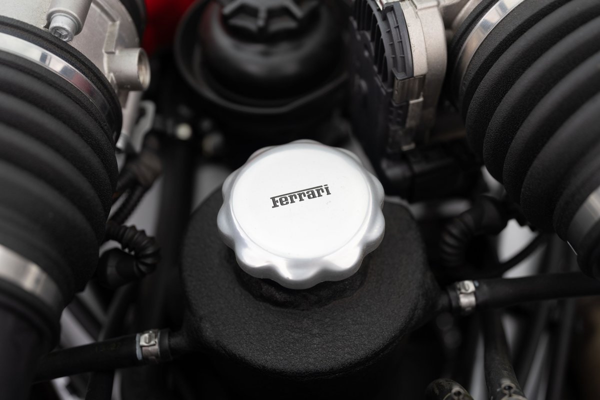 Close-up of the Ferrari F430 engine bay, highlighting the silver Ferrari-branded cap.