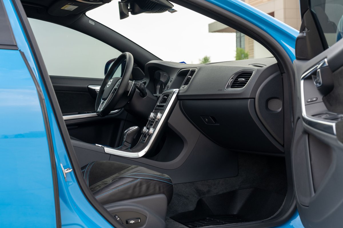 Interior of a 2015 Volvo V60 Polestar in Rebel Blue. Features black leather seats, silver trim, and a digital instrument cluster.
